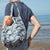 Man on the beach with a filled pacsac over his shoulder 