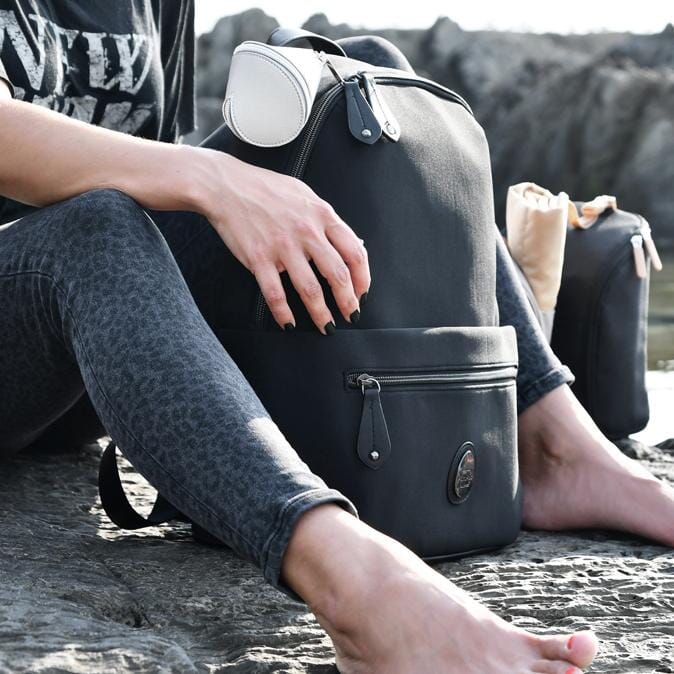 Woman sitting on some rocks with the Rockham Black in front of her