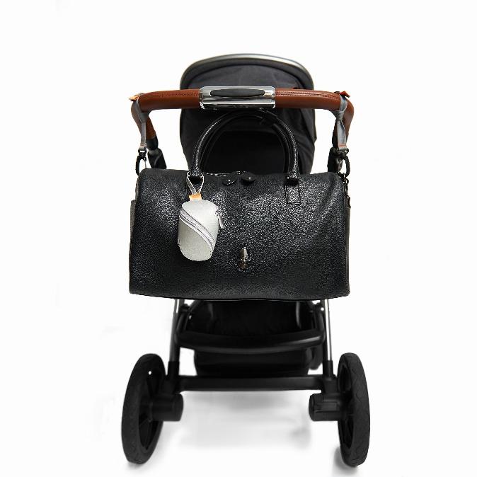 Firenze Pack hanging from pushchair handles using the pram clips