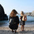 Young girl in a grey dress wearing the toddler pod as a backpack on her back