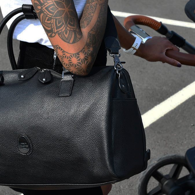 mum carrying the black baby changing bag across her shoulder