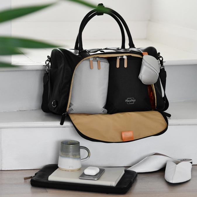 The Firenze Pack Black on a step with the cargo section open to show the pods and shoe and mug in front